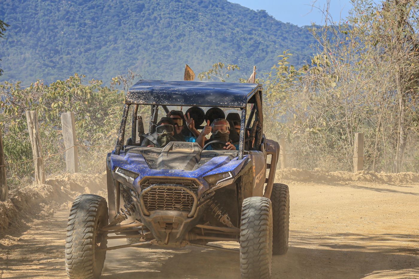 Polaris RZR driving an off-road route surrounded by mountains and nature.