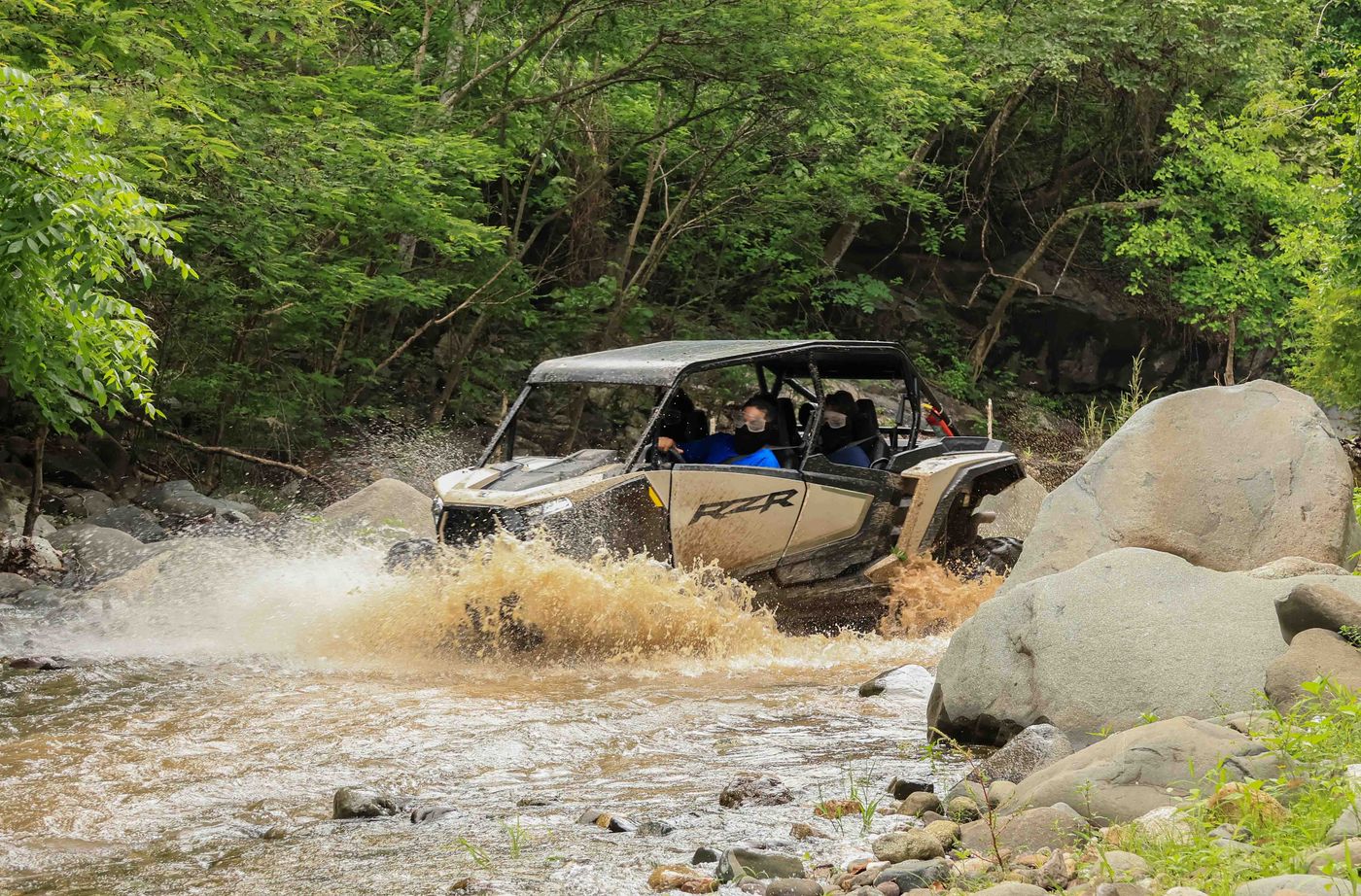 RZR crossing a rocky river during an off-road adventure in Nayarit