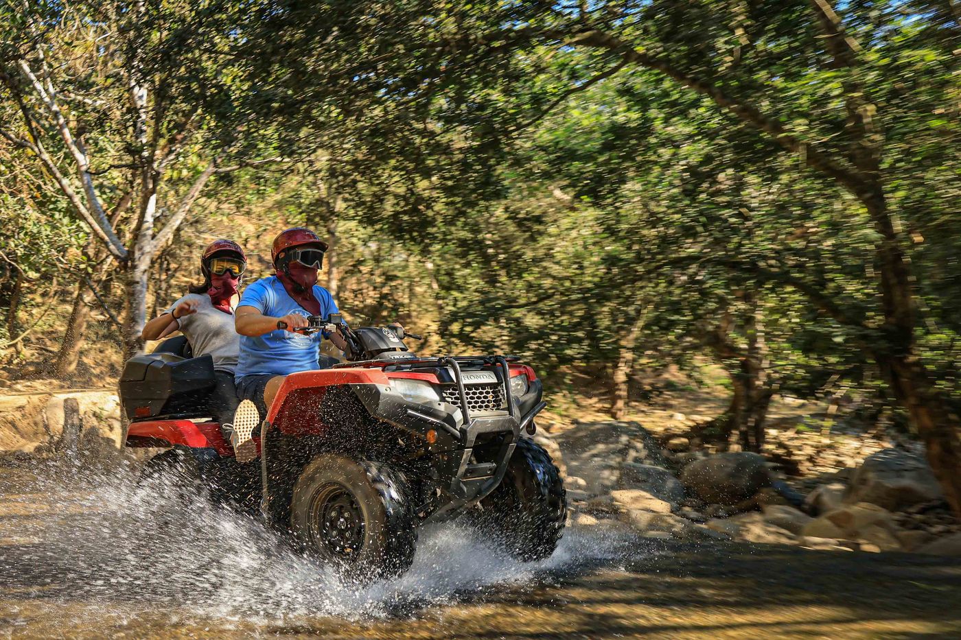 Couple crossing a river on an ATV tour in the mountains of Puerto Vallarta
