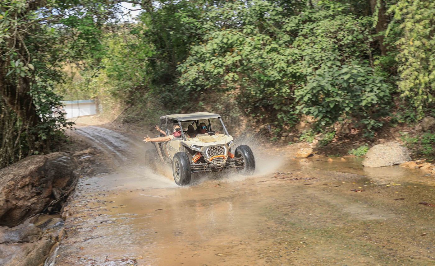 Friends crossing a river in an RZR on a tour in Puerto Vallarta