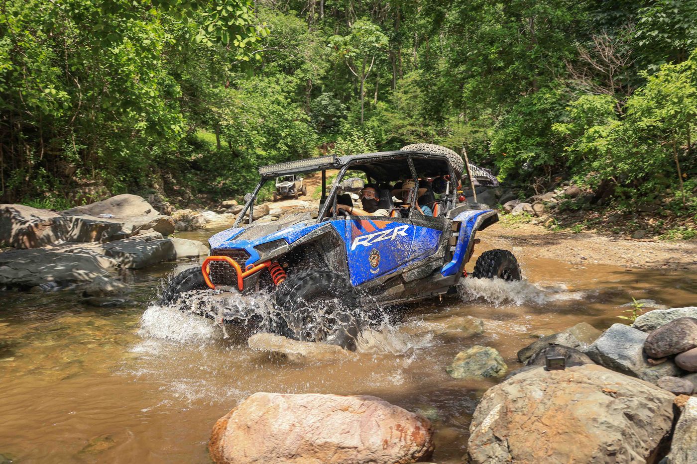 RZR crossing a river during the Capomo Route off-road adventure in Nayarit