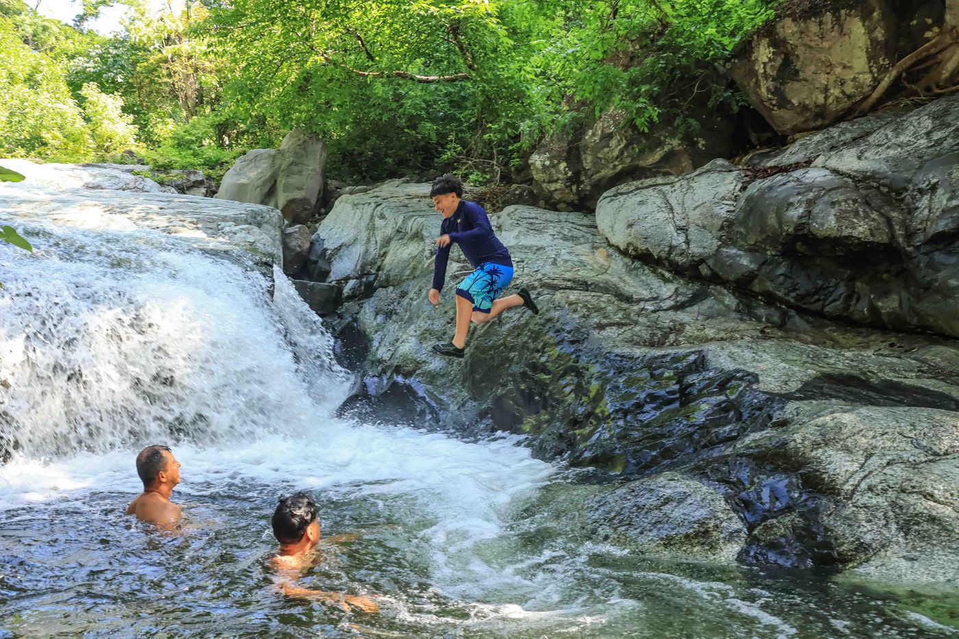 Visitors enjoying a waterfall and natural swimming hole during the Capomo Route in Nayarit