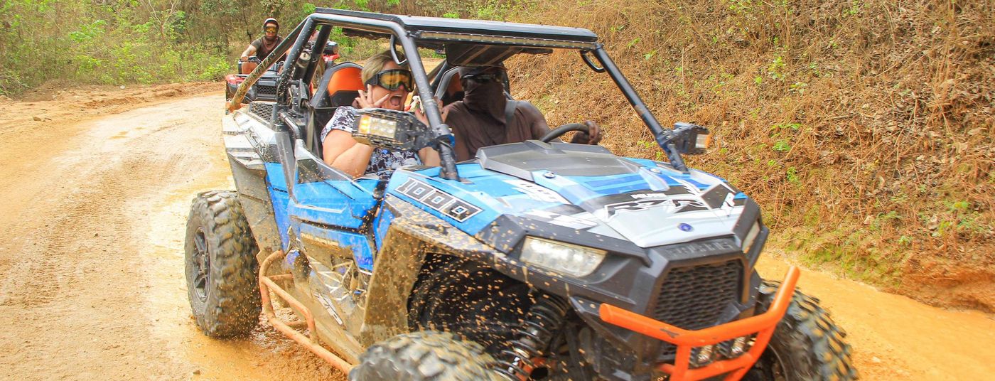 A couple in a UTV going through a puddle on a tour in Puerto Vallarta