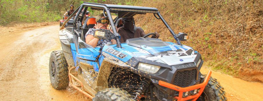 A couple in a UTV going through a puddle on a tour in Puerto Vallarta