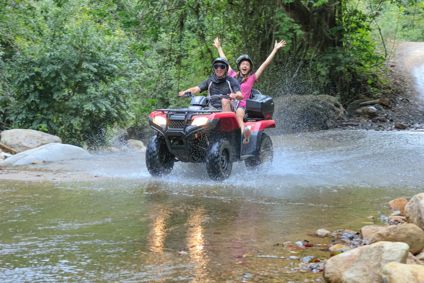 Una pareja recorre un río en un vehículo todoterreno durante una excursión de aventura en Puerto Vallarta.